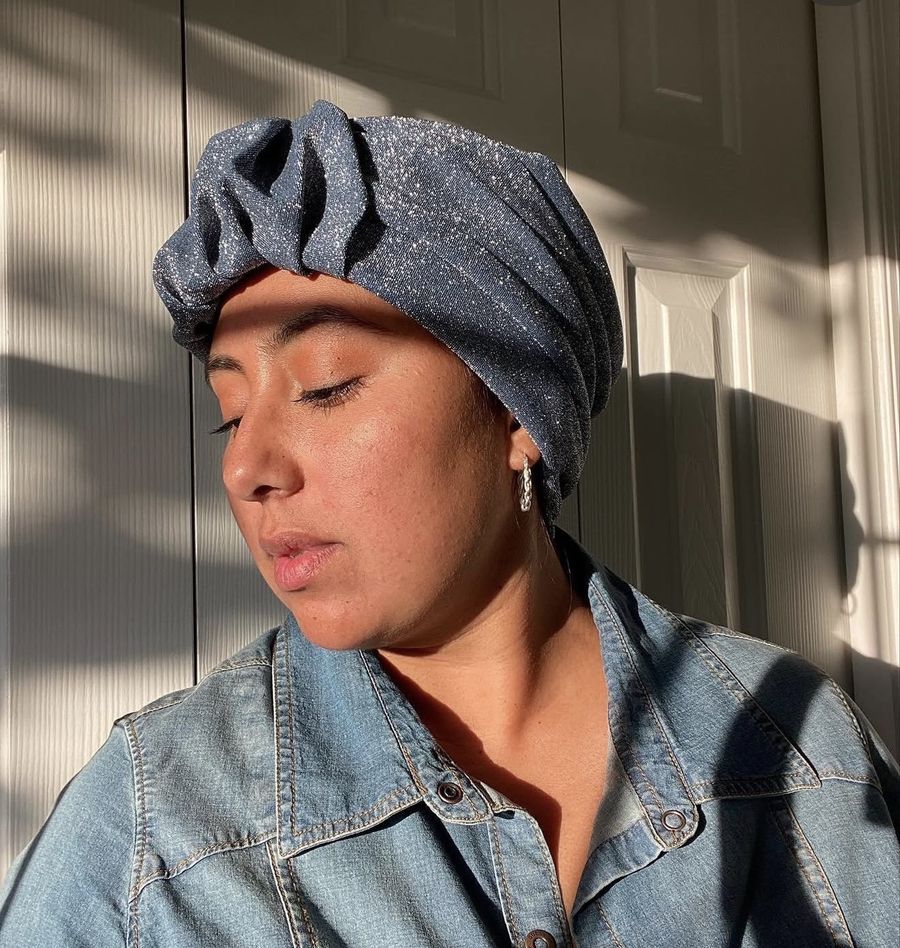 A woman in a sparkly blue headwrap in warm sunlight