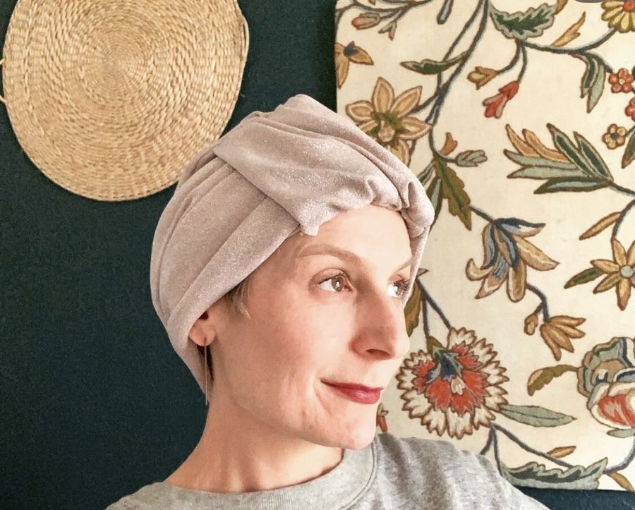 A customer in a blush headwrap at home