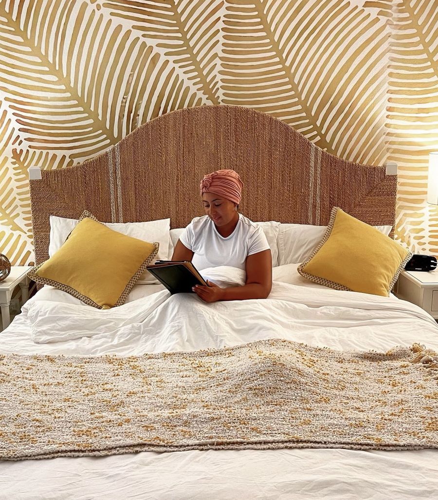 Natalie reading in bed in a rose headwrap